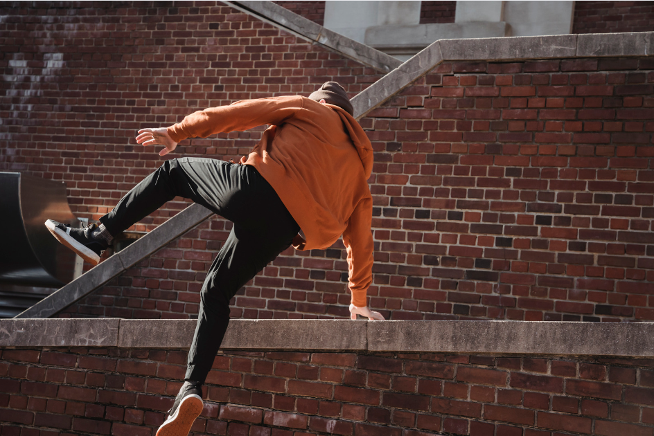 Man jumping over brick wall